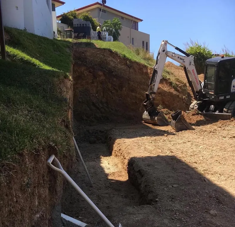 Benching a slope for a retaining wall